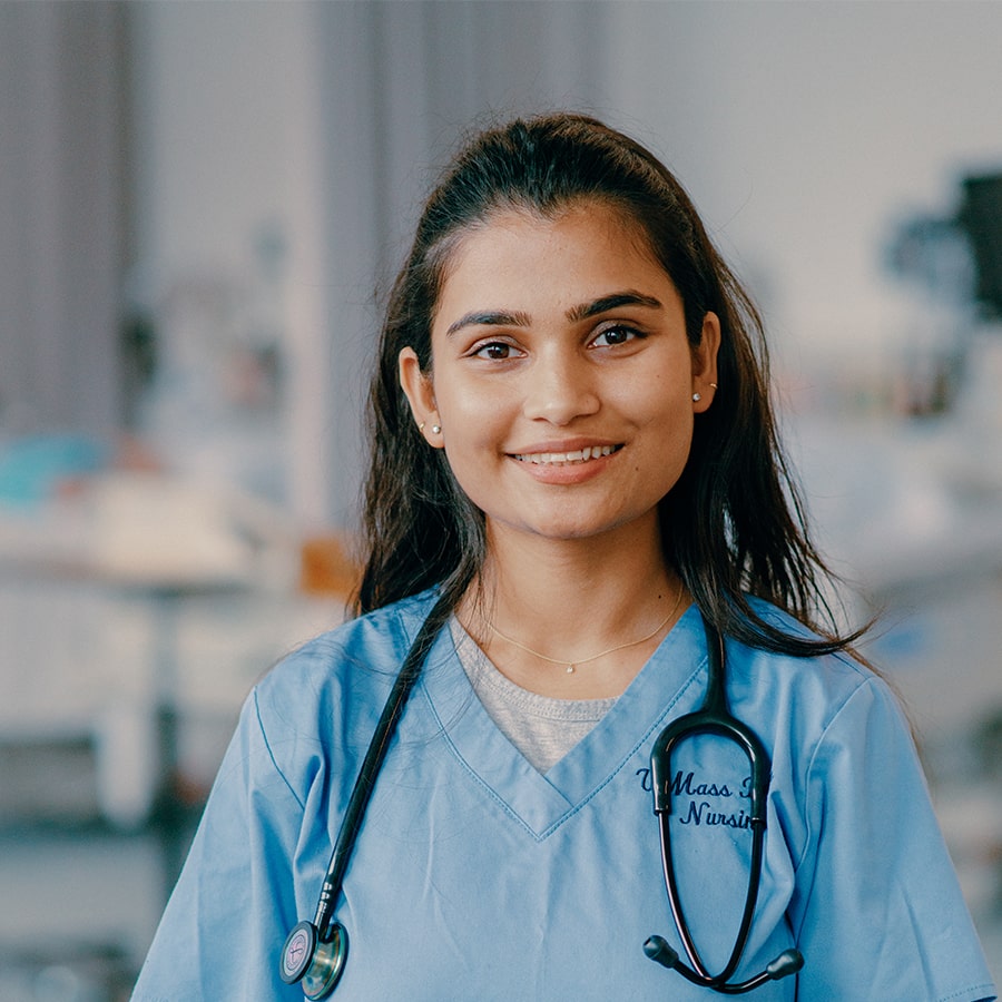 Anjali in nursing scrubs stands in nursing lab.
